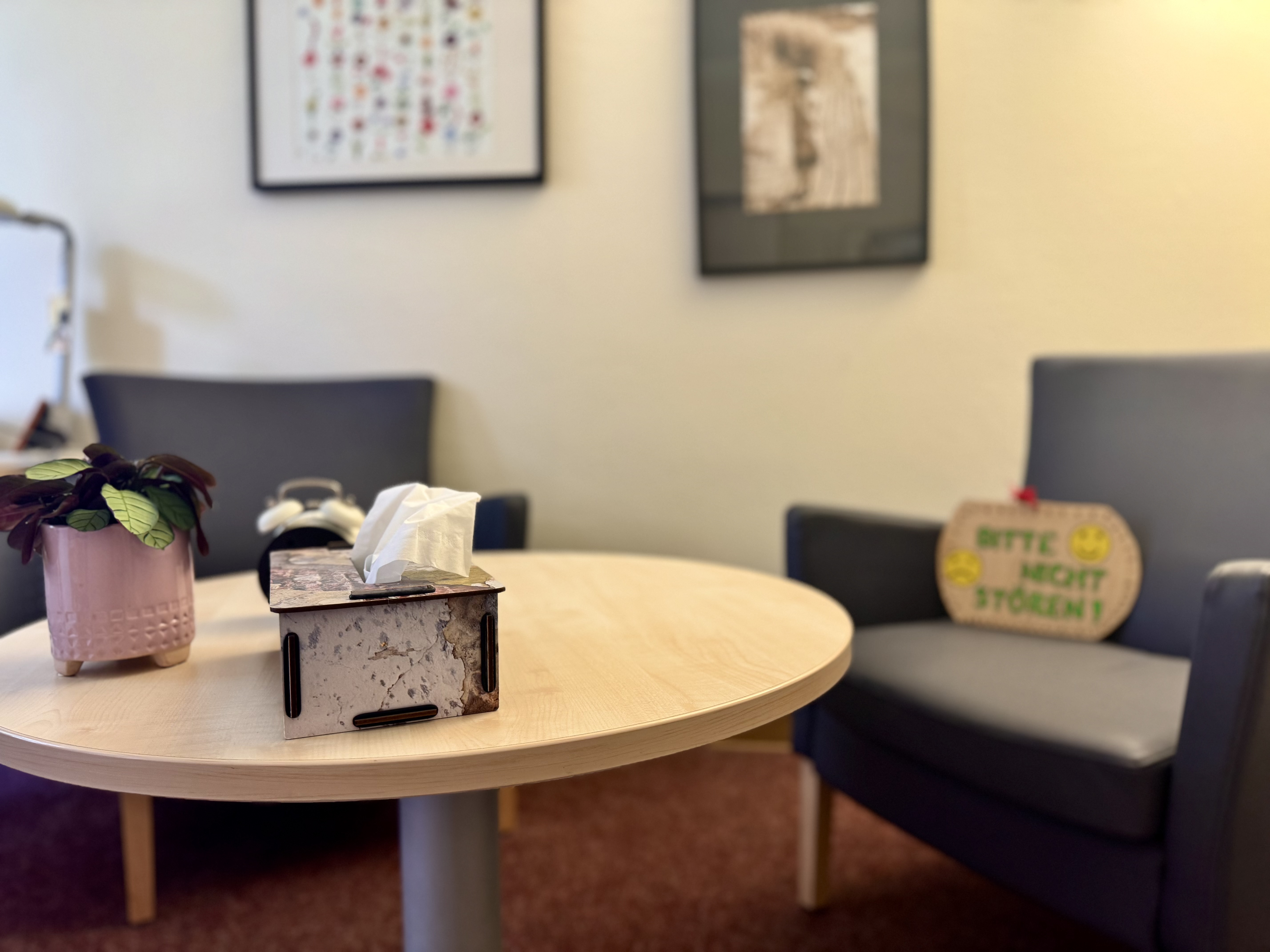 Aufbau eines Therapiegesprächs mit Tisch und Sessel in warmem Licht