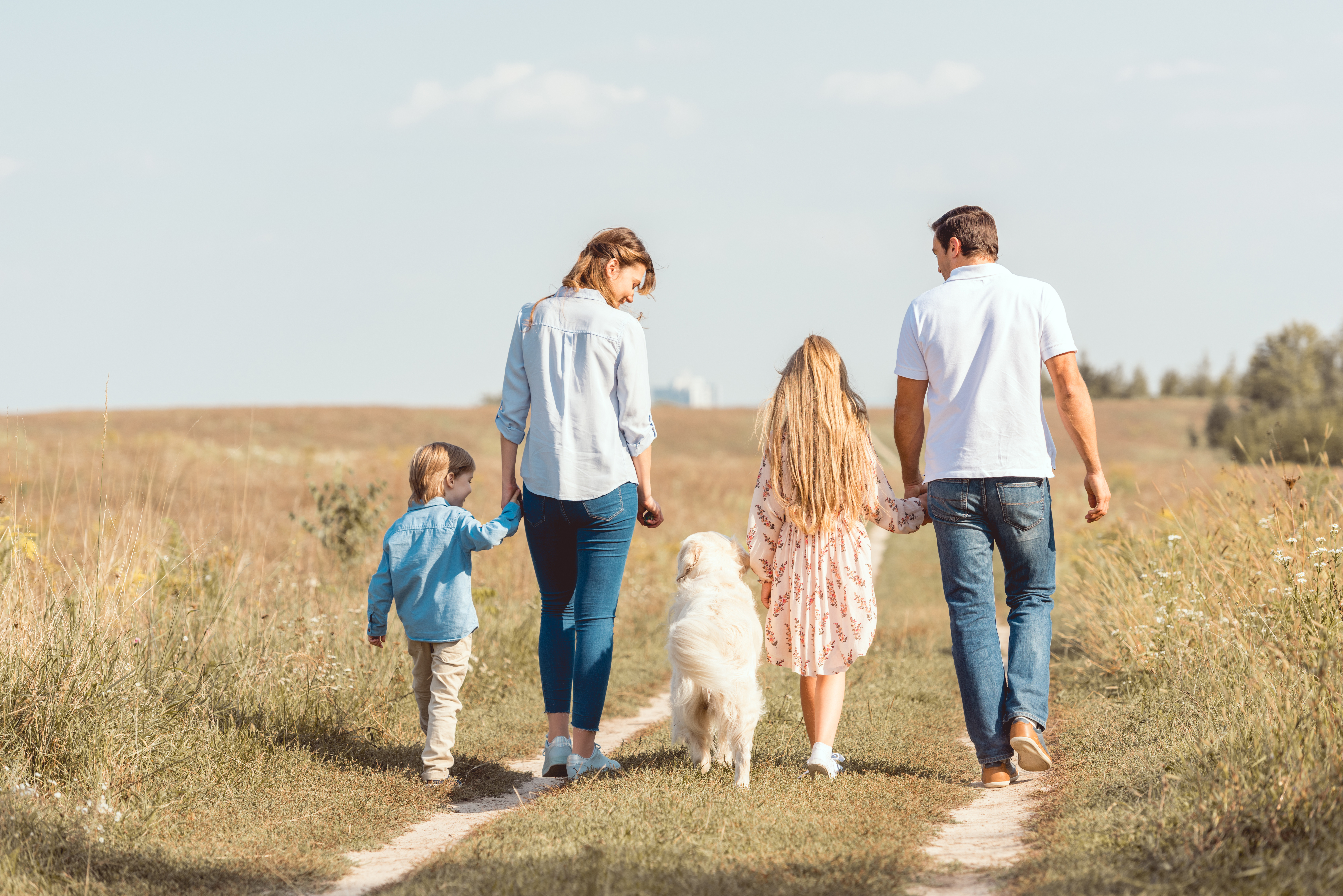 Eine Familie am Strand, Eltern mit zwei Kindern und einem Hund