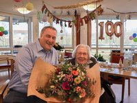 Bürgermeister Eckhard Graf überreicht Heide Manthey einen frühlingshaften Geburtstagsstrauß. (© AMEOS)